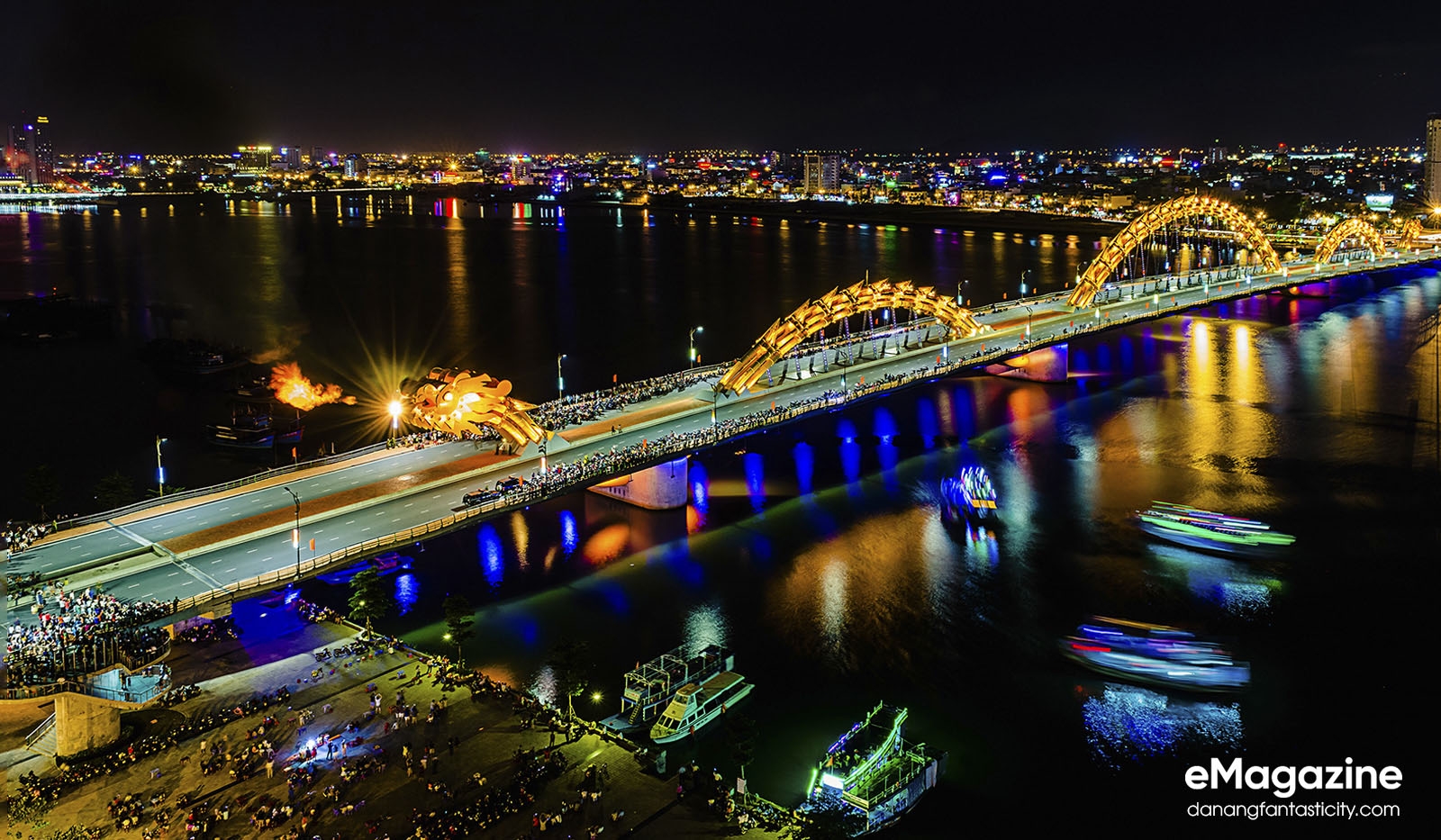 The golden Dragon Bridge breathing fire at night over the Han River with the Da Nang city skyline lit up