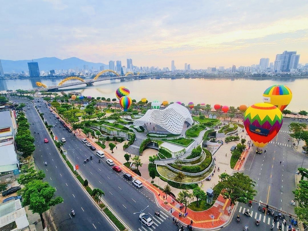 Aerial view of Da Nang riverside park with the Dragon Bridge, colorful hot air balloons and city skyline