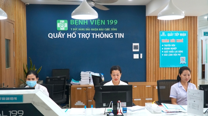 Indoor information desk at Hospital 199 with Benh Vien 199 signage and three staff in white coats