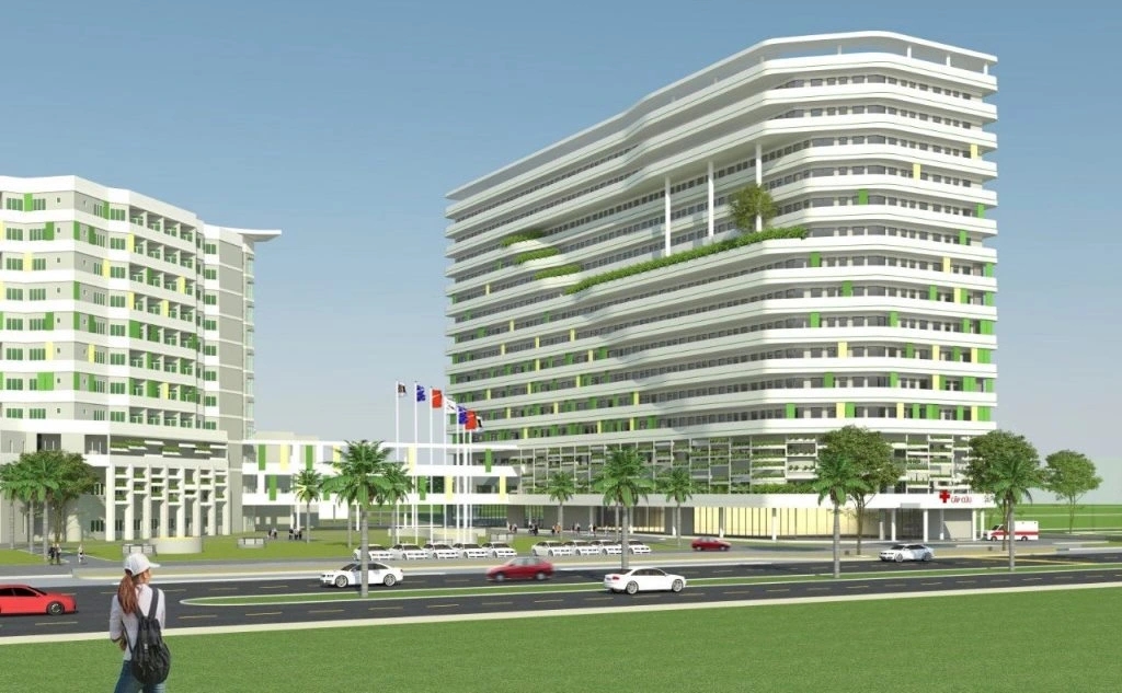 Architectural render of a large modern white multi-storey hospital complex with green balconies and a road in front