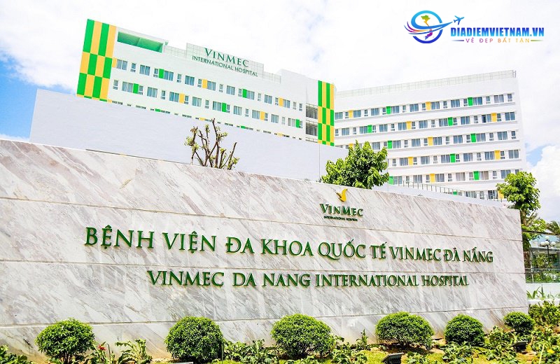 Marble entrance sign for Vinmec Da Nang International Hospital in front of the green and white hospital building