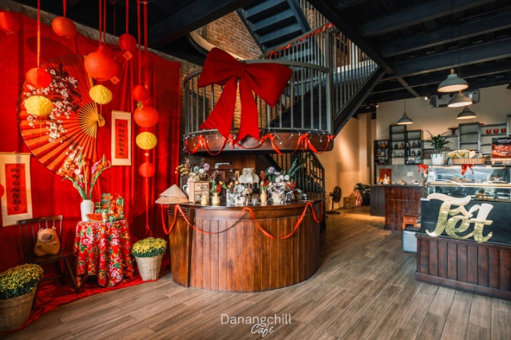 Cafe interior decorated for Lunar New Year with red lanterns, paper fans, a large red bow and a golden Tet sign